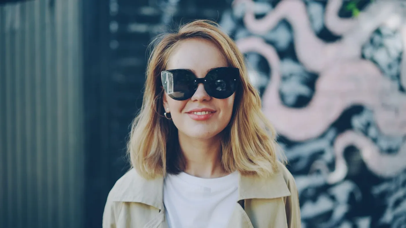 Femme blonde aux lunettes de soleil, veste beige