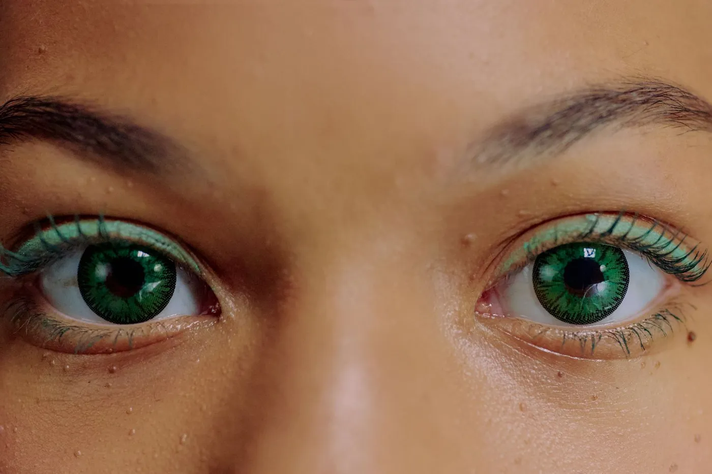 Gros plan d'yeux verts portant des lentilles de couleur